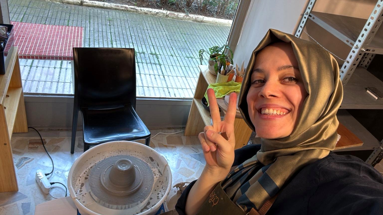Artist ceramicist throwing clay at the wheel in her studio